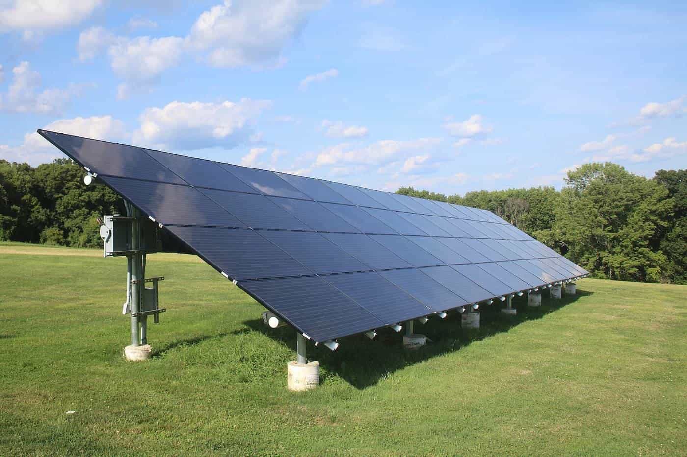 A ground-mounted solar array on a grassy field