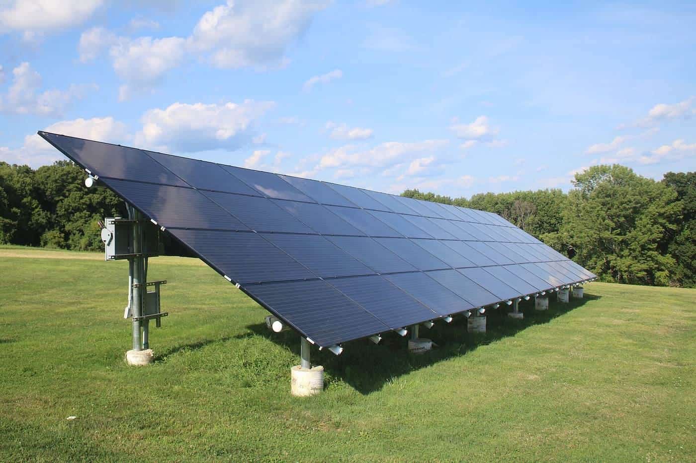 A ground-mounted solar array on a grassy field