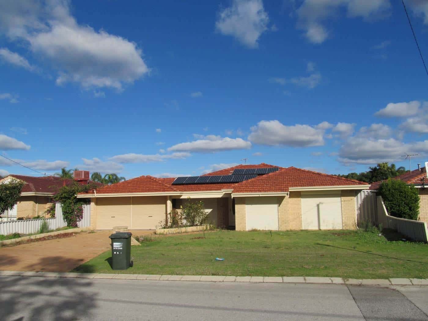A single-storey brick house in Perth with solar panels on its tiled roof