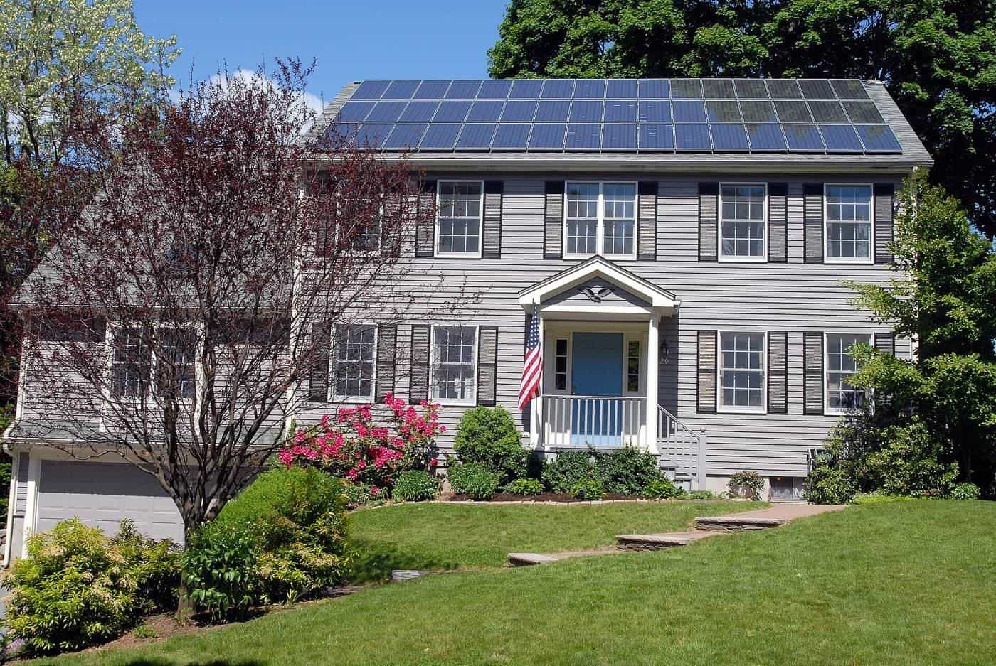 A row of solar panels across the roof of a two-storey house